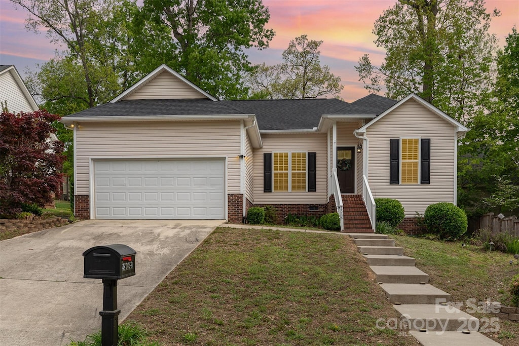 single story home with an attached garage, driveway, roof with shingles, and a front yard