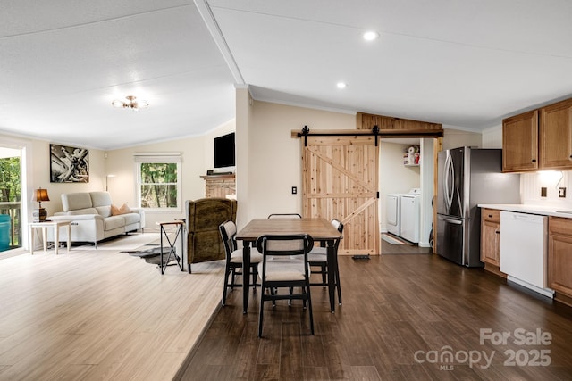 37 Bittersweet Dr, Hendersonville, NC 28792 - dining space with vaulted ceiling, a barn door, washer and dryer, healthy amount of natural light, and dark wood-style flooring