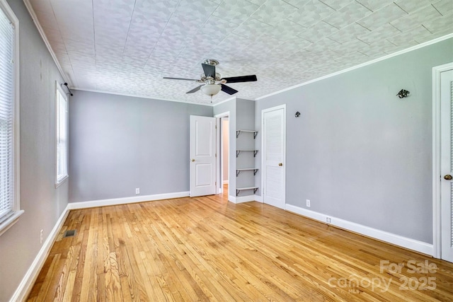 4897 Calico Rd, Lenoir, NC 28645 - unfurnished bedroom with light wood-style floors, crown molding, ceiling fan, and a closet