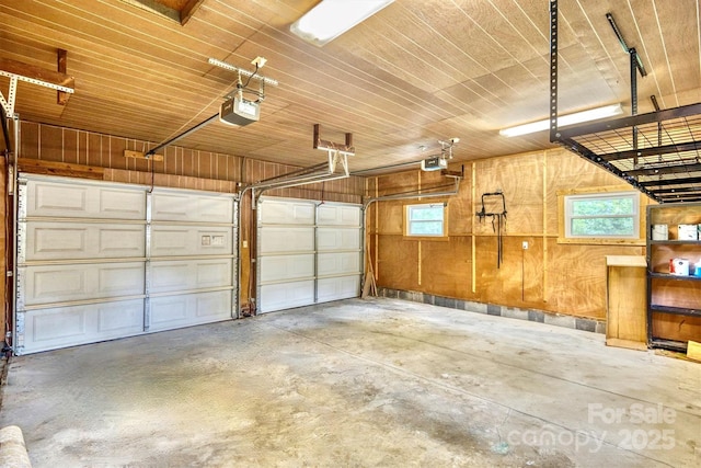 4897 Calico Rd, Lenoir, NC 28645 - garage featuring a garage door opener, wooden ceiling, and wood walls