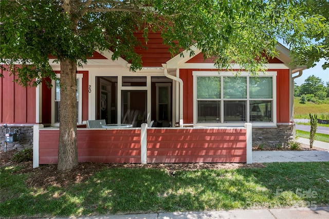 20 Brookstone Pl, Candler, NC 28715 - view of front facade featuring covered porch, stone siding, and a front lawn
