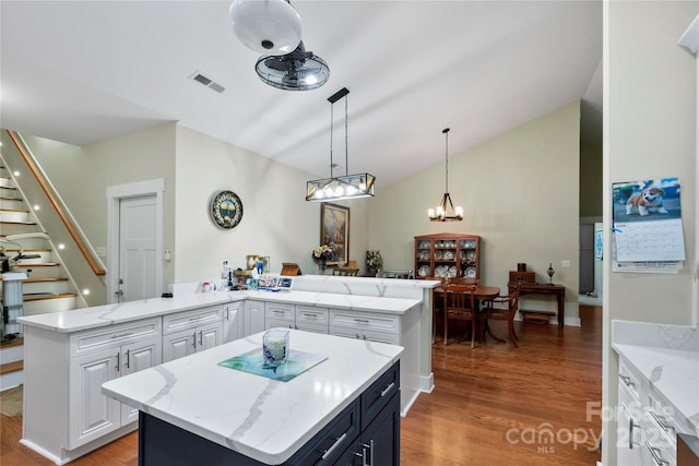 20 Brookstone Pl, Candler, NC 28715 - kitchen with a peninsula, a center island, white cabinets, light wood-style flooring, and high vaulted ceiling