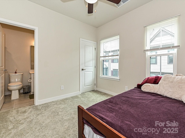 carpeted bedroom featuring visible vents, ceiling fan, ensuite bath, and baseboards