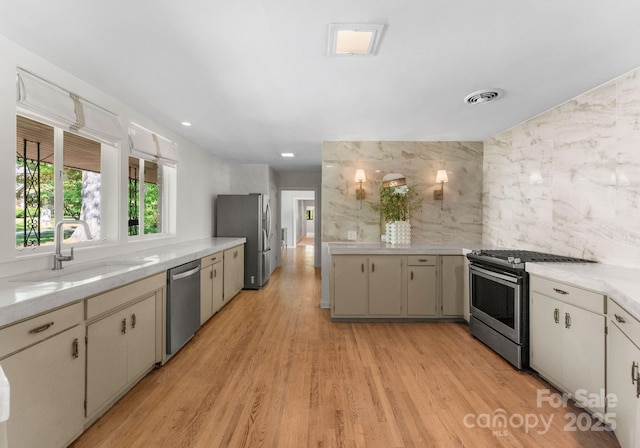916 E Park Dr, Lincolnton, NC 28092 - kitchen with stainless steel appliances, a sink, light wood-type flooring, and tile walls