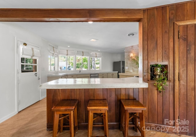916 E Park Dr, Lincolnton, NC 28092 - kitchen with a peninsula, light countertops, a sink, light wood-type flooring, and a kitchen breakfast bar