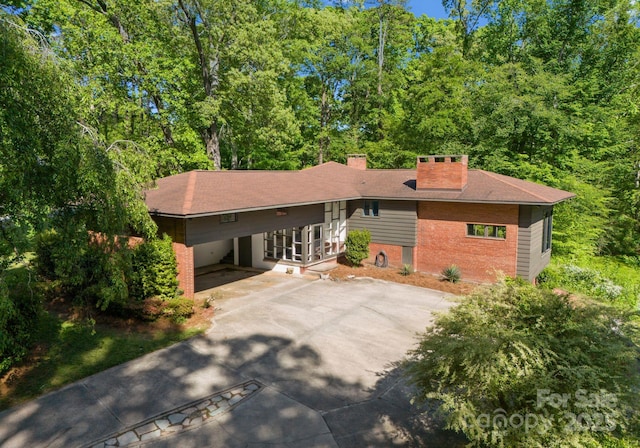 916 E Park Dr, Lincolnton, NC 28092 - view of front of house with concrete driveway, a chimney, an attached carport, and brick siding
