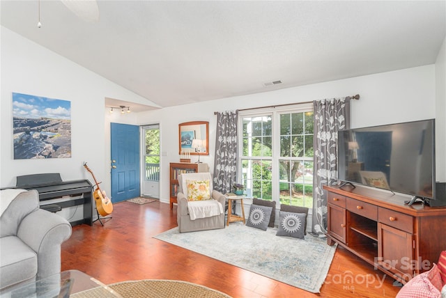 living room featuring visible vents, lofted ceiling, wood finished floors, and a wealth of natural light