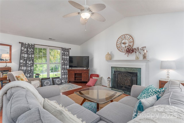 living area with ceiling fan, wood finished floors, lofted ceiling, and a fireplace