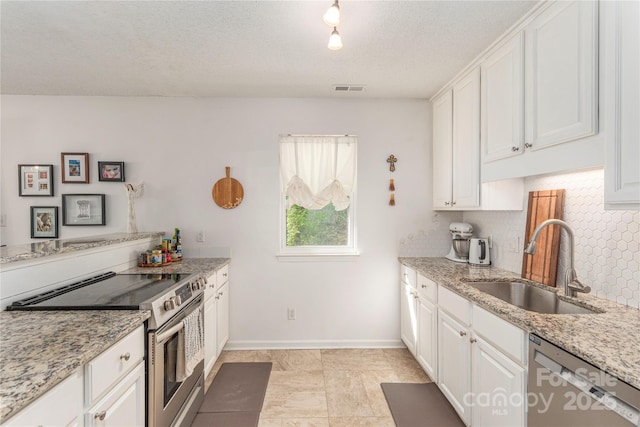 kitchen featuring visible vents, a sink, white cabinetry, and appliances with stainless steel finishes