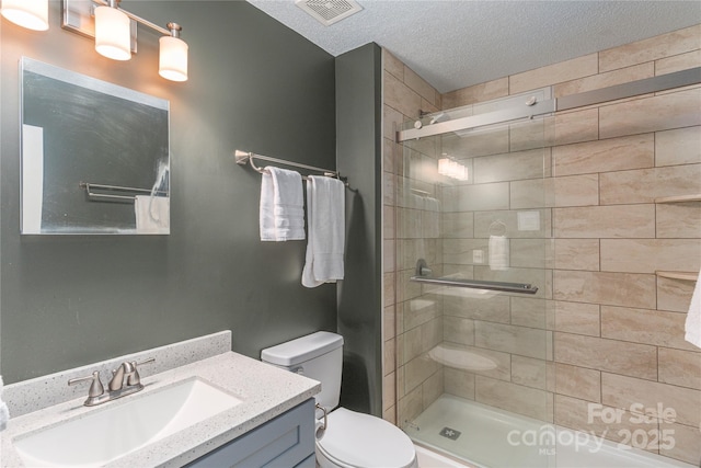 bathroom featuring vanity, a stall shower, toilet, and visible vents