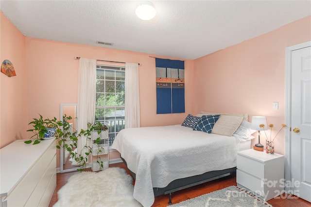 bedroom with visible vents and wood finished floors