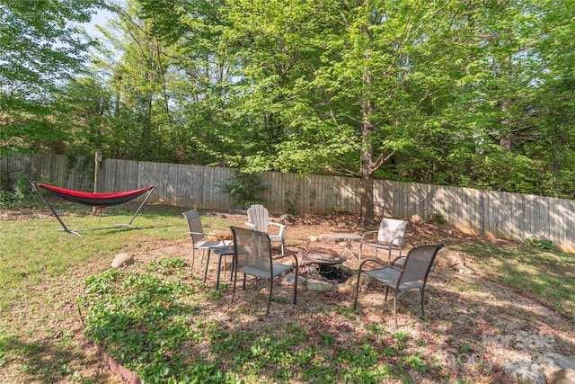 view of yard featuring an outdoor fire pit and fence