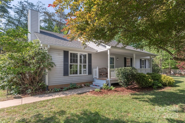 single story home with covered porch, a chimney, a shingled roof, and a front lawn