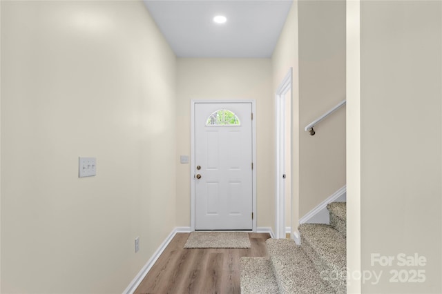 doorway to outside featuring baseboards, stairs, and wood finished floors