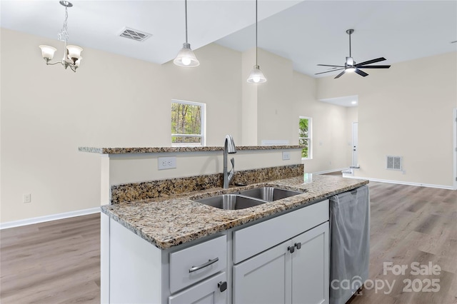kitchen with a sink, visible vents, light wood-type flooring, and dishwasher
