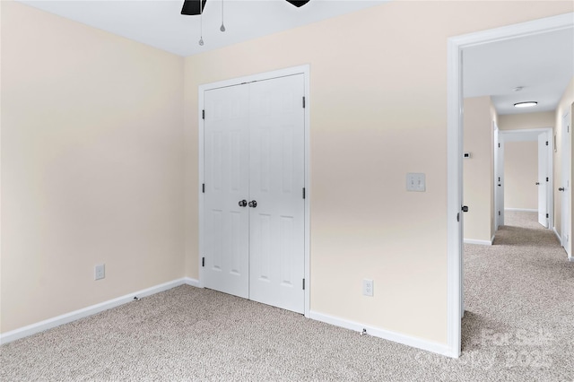 unfurnished bedroom with baseboards, a closet, light carpet, and ceiling fan