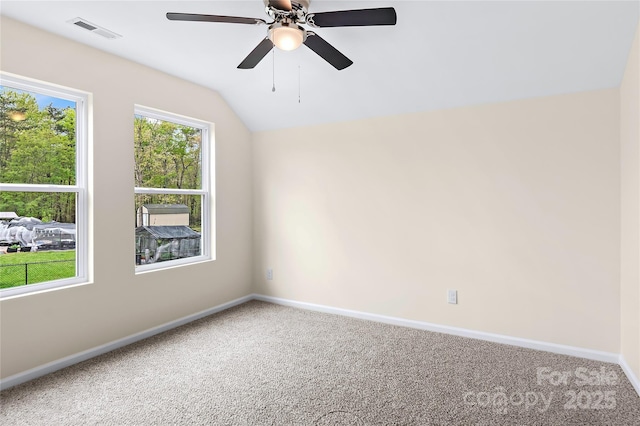 empty room featuring a ceiling fan, visible vents, baseboards, lofted ceiling, and carpet flooring