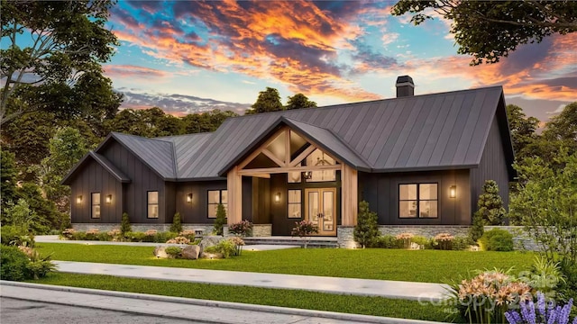 modern farmhouse featuring a chimney, board and batten siding, a front yard, and metal roof