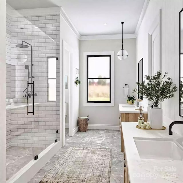 bathroom with a shower stall, marble finish floor, ornamental molding, vanity, and baseboards