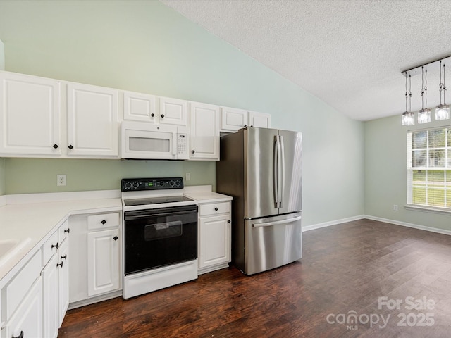 kitchen with a textured ceiling, freestanding refrigerator, electric stove, vaulted ceiling, and white microwave