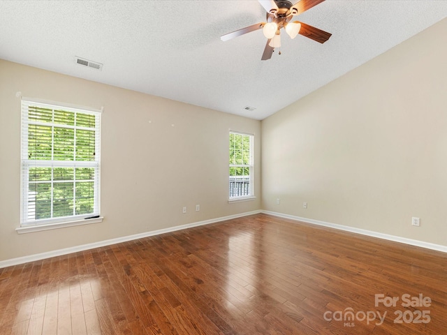 unfurnished room with a ceiling fan, visible vents, baseboards, a textured ceiling, and hardwood / wood-style flooring