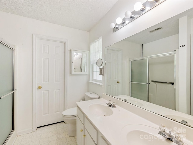 bathroom featuring tile patterned floors, visible vents, a stall shower, and a sink
