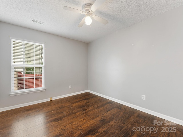 spare room with a ceiling fan, dark wood-style floors, and baseboards