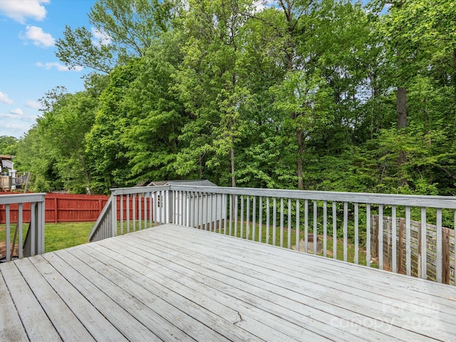 wooden terrace with an outdoor structure, a yard, and a fenced backyard