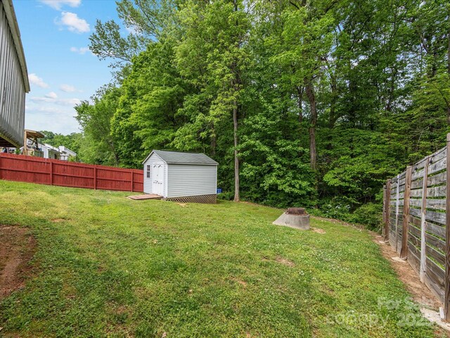 view of yard featuring a fenced backyard, an outbuilding, and a storage shed