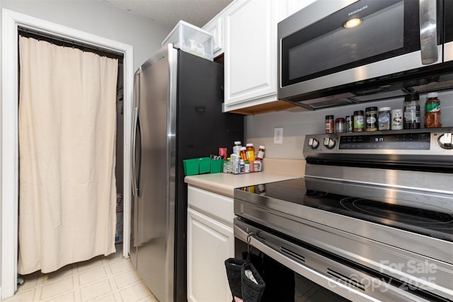 1766 Forest Side Ln, Charlotte, NC 28213 - kitchen featuring light countertops, light floors, white cabinets, and stainless steel appliances
