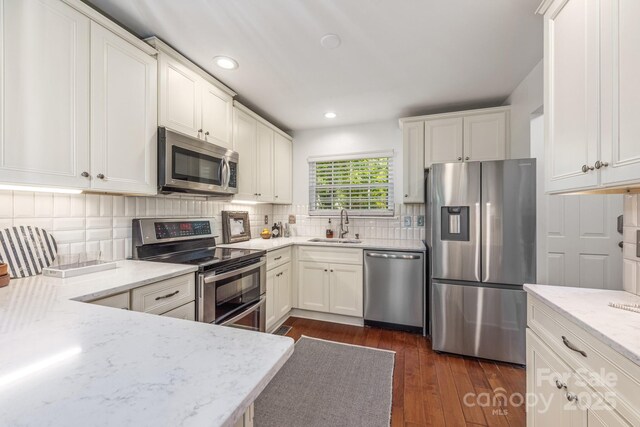 9012 Saint Thomas Ln, Charlotte, NC 28277 - kitchen with dark wood finished floors, light stone countertops, white cabinetry, appliances with stainless steel finishes, and a sink