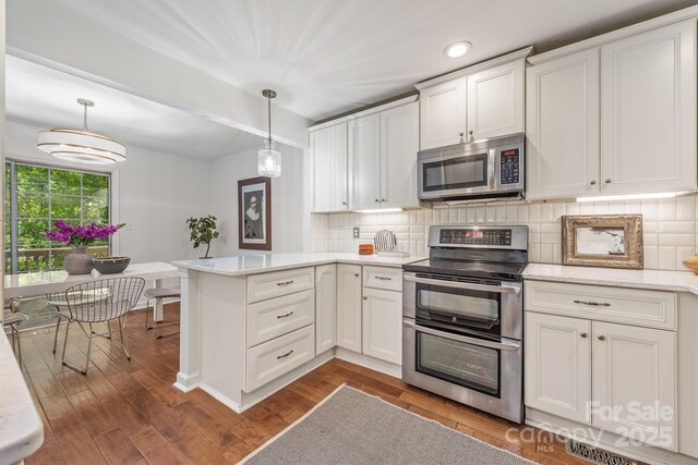 9012 Saint Thomas Ln, Charlotte, NC 28277 - kitchen with a peninsula, white cabinetry, backsplash, and stainless steel appliances