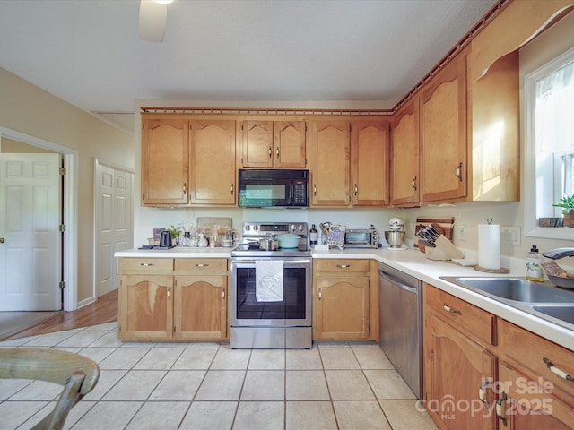 215 6th St, Belmont, NC 28012 - kitchen featuring appliances with stainless steel finishes, light tile patterned floors, light countertops, and brown cabinets
