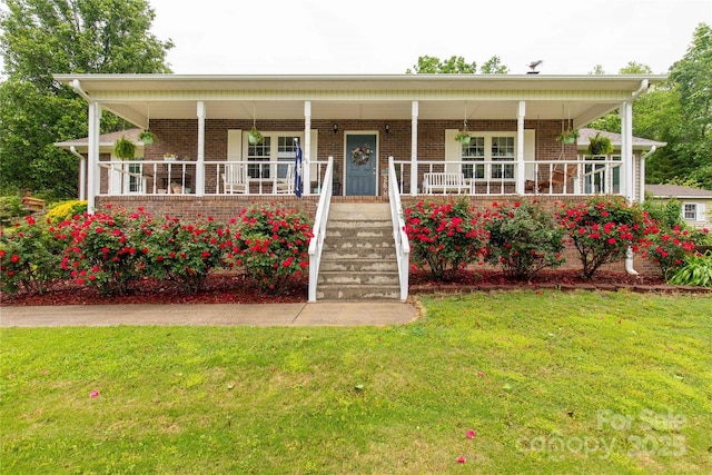 country-style home featuring a front lawn, covered porch, and brick siding