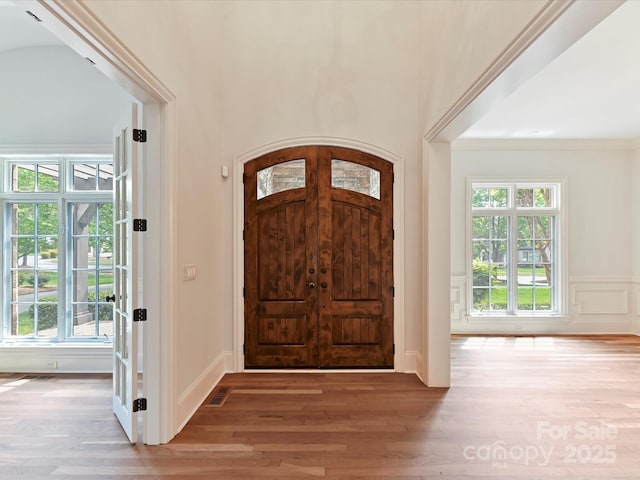 entryway with wood finished floors and a decorative wall