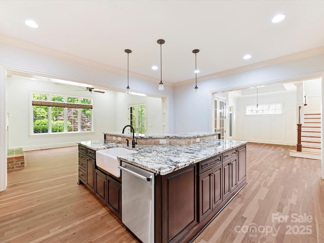 kitchen with light wood-style floors, dishwasher, dark brown cabinetry, and a sink