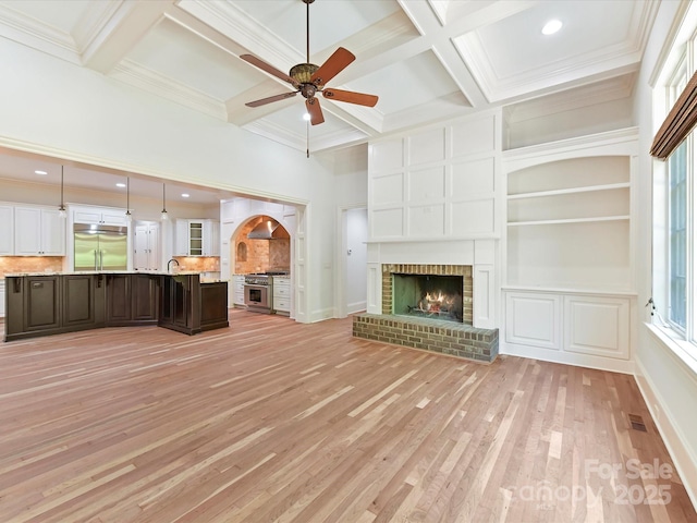 unfurnished living room featuring coffered ceiling, visible vents, beam ceiling, light wood-style flooring, and ceiling fan