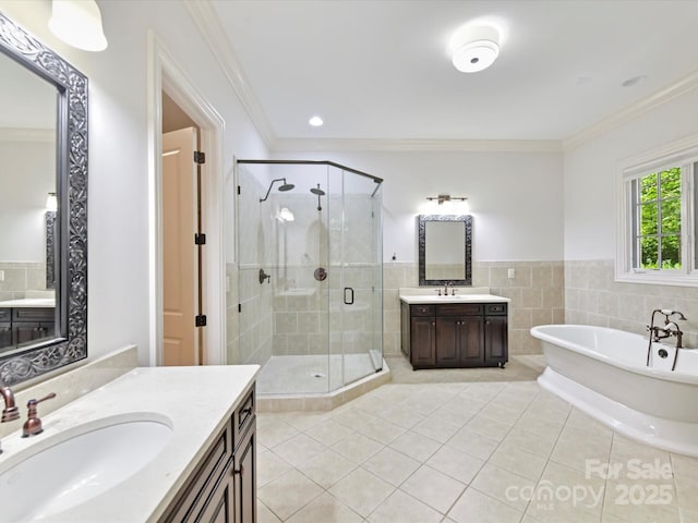 full bath with a shower stall, tile patterned floors, ornamental molding, and a sink