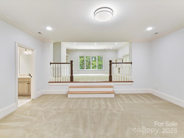 spare room with light colored carpet, baseboards, ornamental molding, and recessed lighting