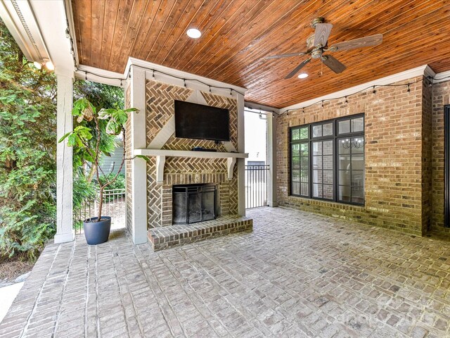view of patio / terrace featuring a ceiling fan and an outdoor brick fireplace
