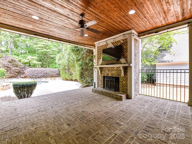 view of patio featuring a ceiling fan and an outdoor brick fireplace