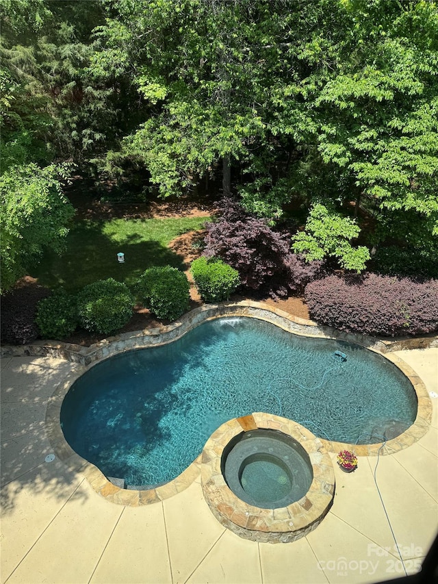pool with a patio and an in ground hot tub