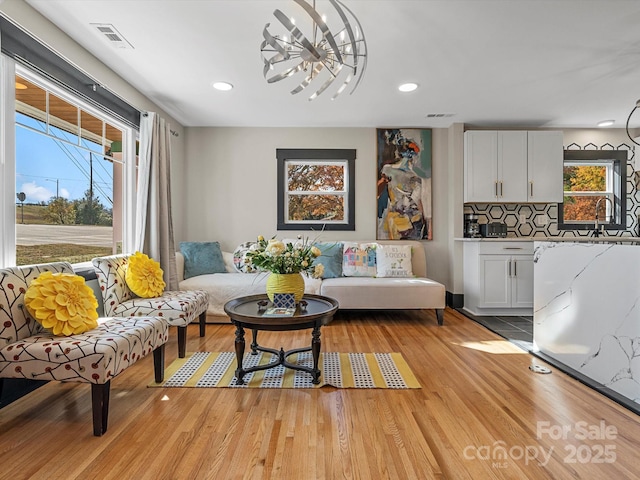 living room featuring a wealth of natural light, light wood finished floors, and visible vents