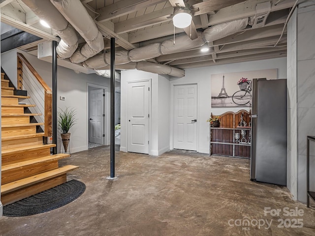 finished below grade area featuring freestanding refrigerator and stairs