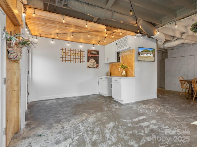 basement featuring track lighting, visible vents, and baseboards