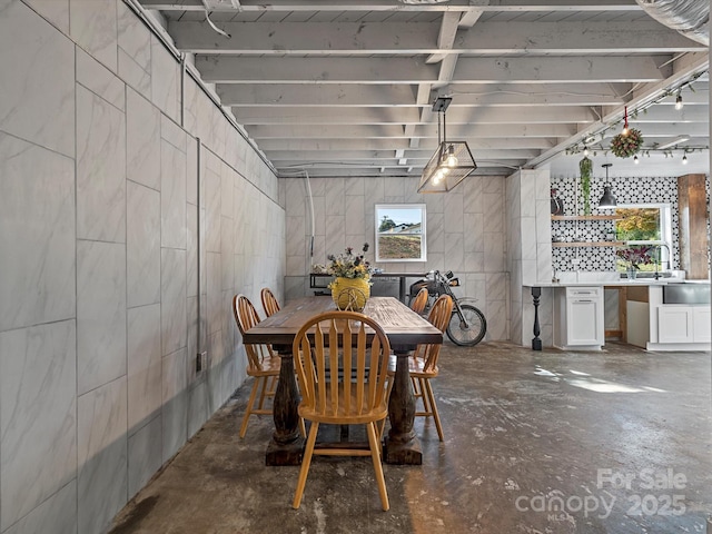 dining area featuring unfinished concrete flooring