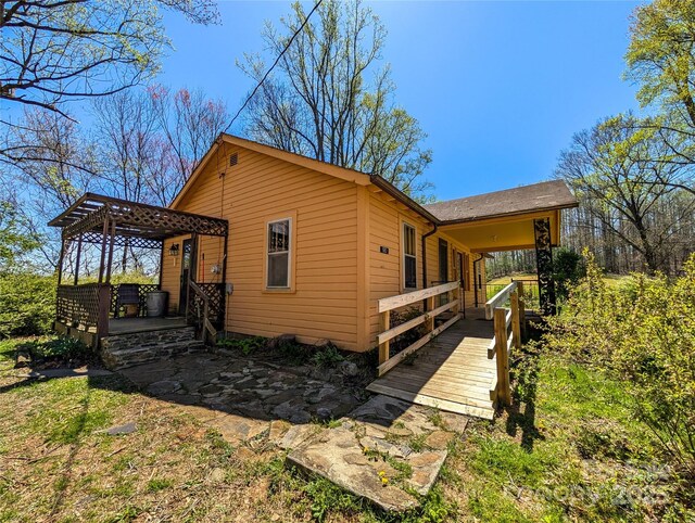 view of side of home with a pergola and a deck
