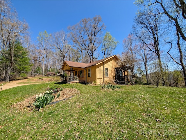 view of side of property with a lawn and covered porch