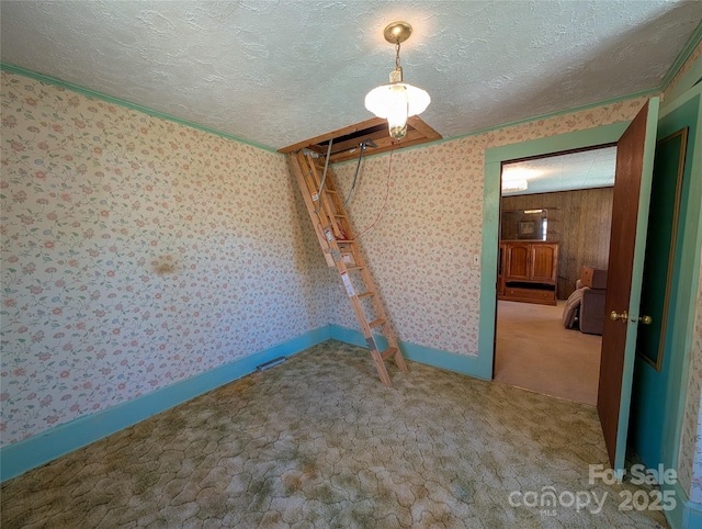 unfurnished room with baseboards, a textured ceiling, wallpapered walls, and carpet