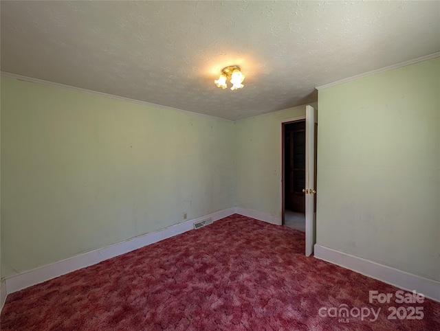 empty room with a textured ceiling, baseboards, visible vents, carpet, and crown molding